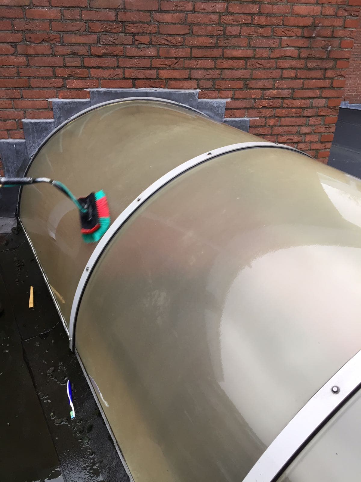 Reiniging van een overkapping met borstel